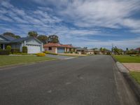 a row of houses on a residential street in a suburb area with grass and shrubs