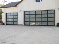 the garage is white with black trim and a big screen door in front of the garage