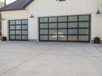 the garage is white with black trim and a big screen door in front of the garage