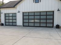 the garage is white with black trim and a big screen door in front of the garage