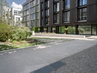 a black building on a street with grass in front of it in the daytime time