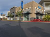 a building that has a parking meter on the sidewalk and a sky background that says alhammed