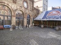 this is a restaurant on the side of a brick street with barrels stacked on top of each other