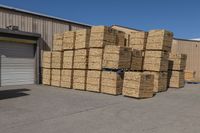 several piles of hay stacked in a warehouse near a parking lot area under a blue sky