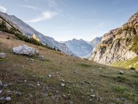 a person riding a horse in a mountainside setting setting in the sun and some rocks