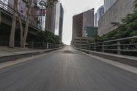 a photo taken while riding a motorcycle down a long road in the middle of city