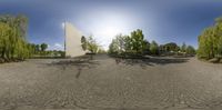 a panorama view of an empty parking lot with trees and trees around it on a sunny day