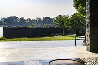 the view outside an open patio door overlooking a river and trees and a park area