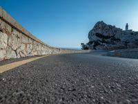 a very large hill near the sea and a rock formation on it's edge