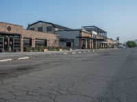 the empty street outside of the business district is empty and deserted with vehicles parked in it