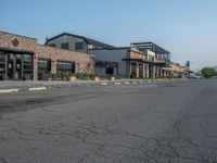 the empty street outside of the business district is empty and deserted with vehicles parked in it