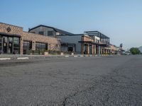 the empty street outside of the business district is empty and deserted with vehicles parked in it