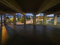 a view of an outside parking garage through the windows looking over the street at some trees and buildings