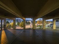 a view of an outside parking garage through the windows looking over the street at some trees and buildings