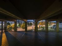 a view of an outside parking garage through the windows looking over the street at some trees and buildings