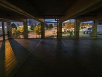 a view of an outside parking garage through the windows looking over the street at some trees and buildings