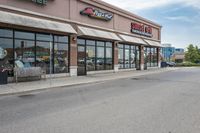 a restaurant on the corner of a road, with an outdoor parking area and a red stop sign that reads sunshine pizza