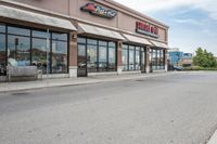 a restaurant on the corner of a road, with an outdoor parking area and a red stop sign that reads sunshine pizza