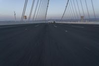 the road is long and there are cars driving over it on its side of the bridge