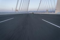 the road is long and there are cars driving over it on its side of the bridge