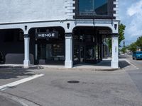 a small business in a city on the street corner with signs on it that read,'heritage henge '