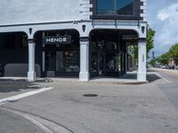 a small business in a city on the street corner with signs on it that read,'heritage henge '