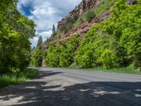 the red rocks are high up on the side of the road and it is an amazing color