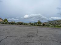 a mountain sits in the distance in a parking lot with a few trees and shrubbery