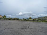 a mountain sits in the distance in a parking lot with a few trees and shrubbery