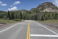 an empty empty road in the country side and mountains in the background in the summer