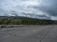 a mountain sits in the distance in a parking lot with a few trees and shrubbery