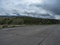 a mountain sits in the distance in a parking lot with a few trees and shrubbery