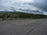 a mountain sits in the distance in a parking lot with a few trees and shrubbery