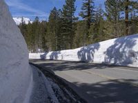 a white wall with some snow on it and a road that is half closed off