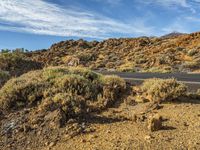 a road winding through a desert landscape under a clear blue sky on the mountain, there are no clouds