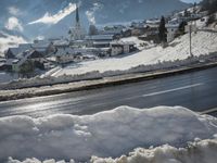 Road in Germany through snowy alpine landscape with mountain range and reflection in water