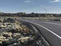 a paved road in the middle of nowhere with rocks on both sides of the road