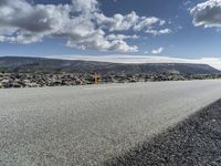 Road through the Icelandic Highland landscape with mountains and grass