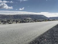 Road through the Icelandic Highland landscape with mountains and grass