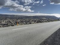 Road through the Icelandic Highland landscape with mountains and grass