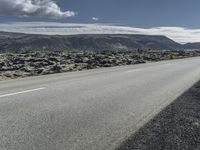 Road through the Icelandic Highland landscape with mountains and grass