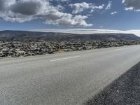 Road through the Icelandic Highland landscape with mountains and grass