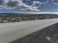 Road through the Icelandic Highland landscape with mountains and grass