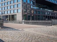 the large building is made of concrete and has metal railings around it, which are made of brick