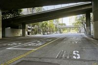 a picture of an empty road in front of a very tall building on a bridge