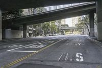 a picture of an empty road in front of a very tall building on a bridge