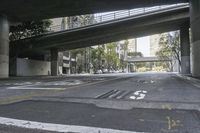 a picture of an empty road in front of a very tall building on a bridge