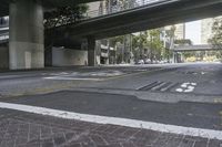 a picture of an empty road in front of a very tall building on a bridge