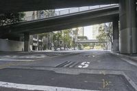 a picture of an empty road in front of a very tall building on a bridge