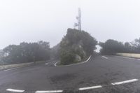 a road with a corner on a foggy day with no cars driving or standing